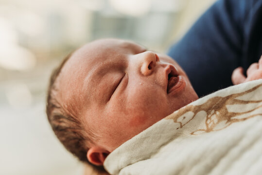 Close up image of newborn baby boy in window light