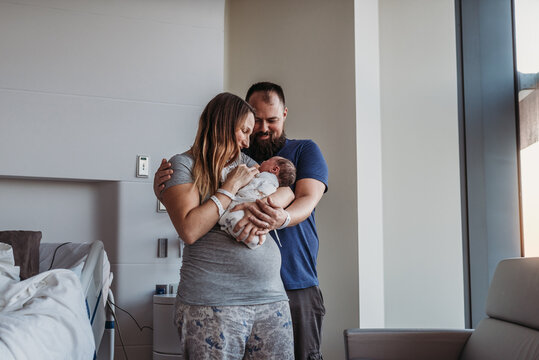 Newborn baby boy being cradled by new parents in birthing center