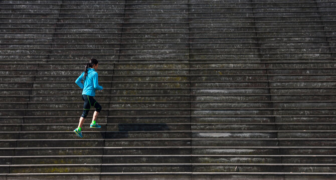 Woman running up wooden stairs in Paris