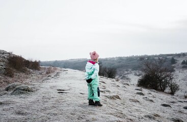 young girl stood on the top of a hill in the English countryside