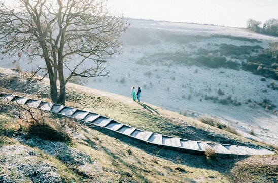 two kids stood on top of a big hill in the countryside in England