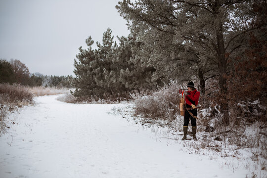 Young man pulling arrow out of vintage quiver in winter woods