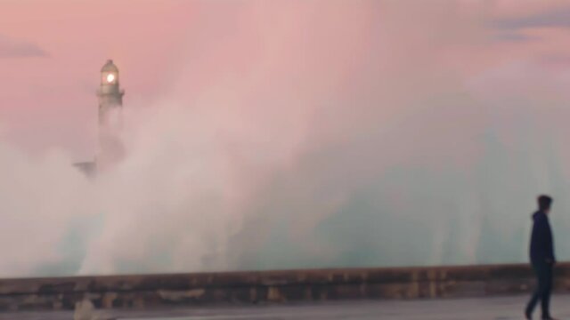 wave crashing on malecon with the Faro Castillo del Morro lighthouse. Havana, Cuba
