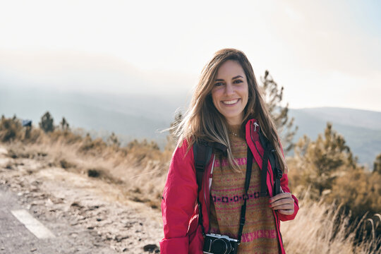 pretty girl smiling while looking at the camera in nature during sunset. Relax time on holiday concept travel