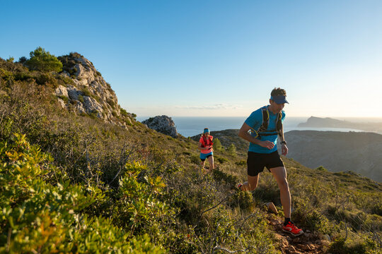Man and woman running on mountain trail, Calpe, Costa Blanca, Alicante