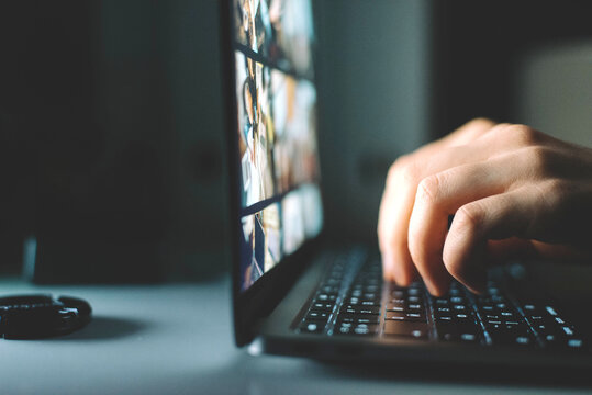 Anonymous woman working on laptop at night