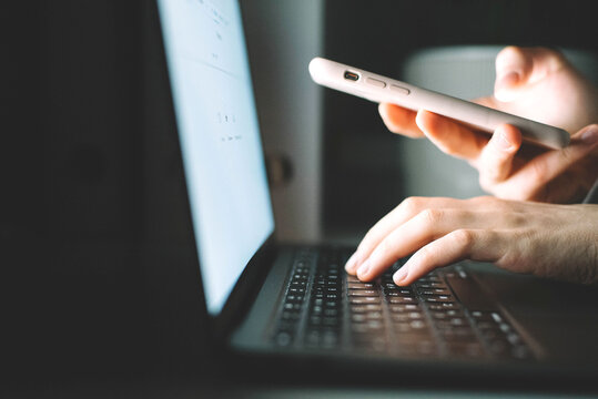 Anonymous woman working on laptop at night