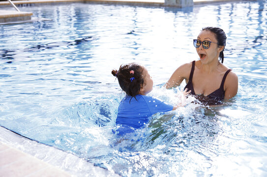 Mother and daughter having fun in swimming pool