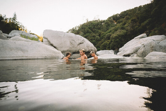Three Friends Lay in a Pool of Water at Dusk