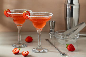 Fresh homemade strawberry margarita cocktails with bar tools on the table. Preparing summer refreshing cocktails