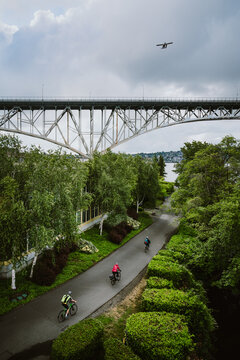 Aerial view of cyclists on urban bike trail with bridge in distance