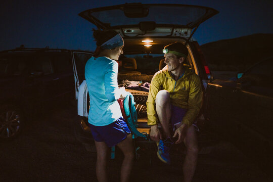 Man and Woman sit and laugh after a long trail run in the mountains