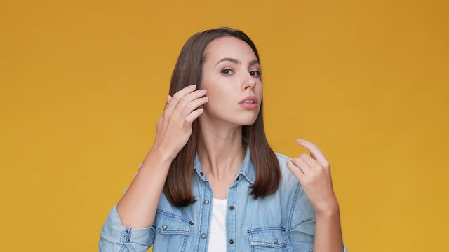 Lady look touch hair dander lotion isolated beige mustard color background