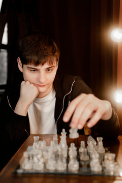 Young guy playing glass chess