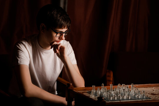 Guy in glasses looking at chess board