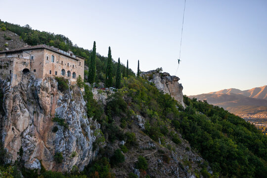 Slackline next to a medieval abbey on an overhanging rock