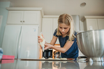 Young girl baking macarons in kitchen