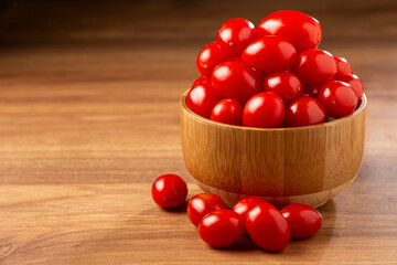 Fresh grape tomatoes in a bowl on the table.
