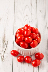 Fresh grape tomatoes in a bowl on the table.