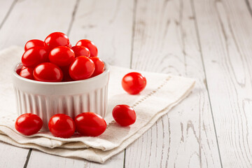 Fresh grape tomatoes in a bowl on the table.