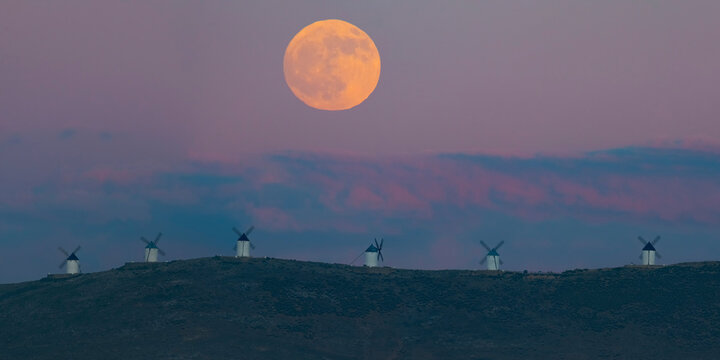 Panoramic view of old windmills with full moon , Consuegra, Spain