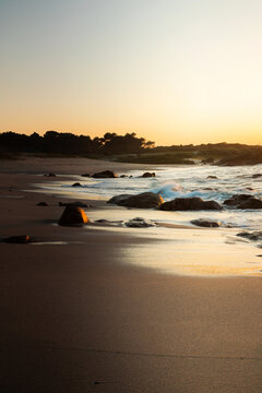 Sunset on a beach with rock formations on the Galician coast