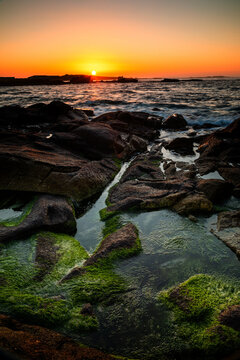 Sunset on a beach with rock formations on the Galician coast