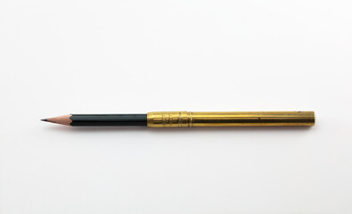 Extend, enlarge, increase, concept image, a short pencil in a brass pencil extender, isolated on neutral white.