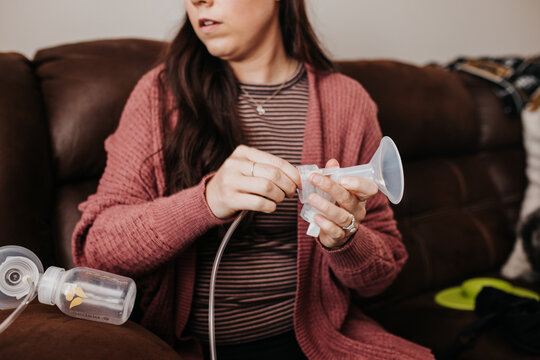 Mom Prepares Breast Pump In The Living Room While Sitting On The Couch