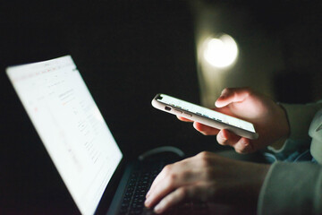 Anonymous woman working on laptop at night