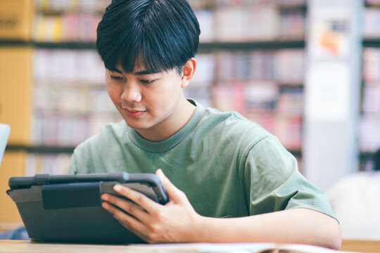 Young collage student using computer and mobile device studying