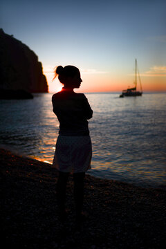 Silhouette of a contemplative young woman enjoying a beautiful sunset