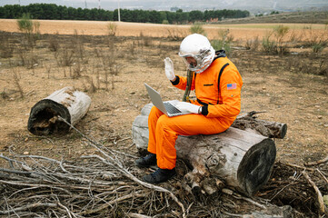 Man dressed as astronaut using laptop