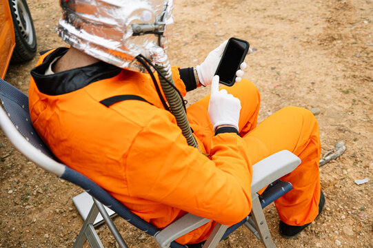 Man dressed as astronaut using smart phone