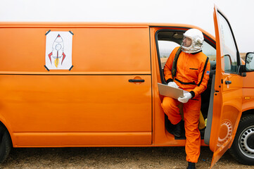 Man dressed as astronaut using laptop