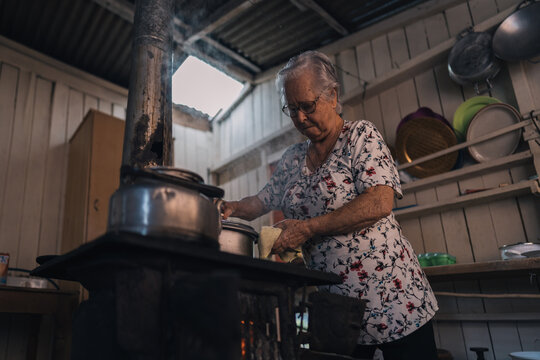 Senior woman cooking in a old retro stove