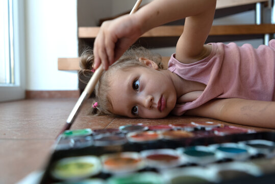girl paints a picture on the floor