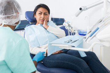 Fototapeta na wymiar Woman complains of toothache to dentist
