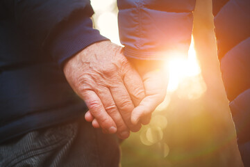Senior elderly couple holding hands walking together, love, support and happy couple concept - obrazy, fototapety, plakaty