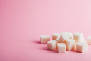 Fototapeta na wymiar Sugar cubes on pastel pink background, copy space