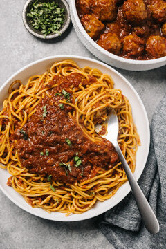Spaghetti marinara with a side dish of meatballs