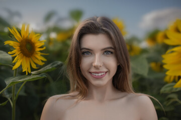 Beautiful smiling young woman on a field of sunflowers