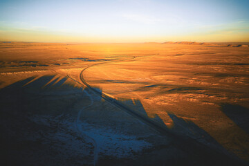 A dirt road in the shadows of Shiprock mountain formation, New Mexico