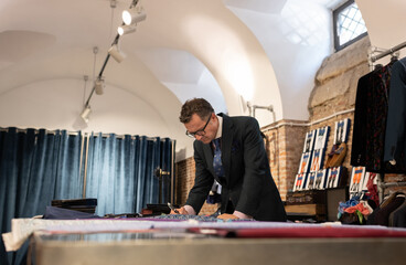 Mature fashion designer sketching in loft studio