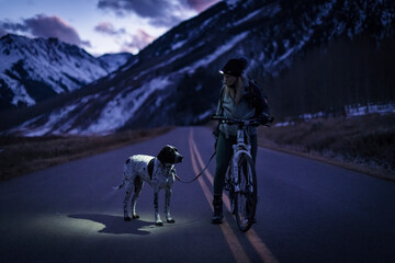 Woman cycling with dog during vacation