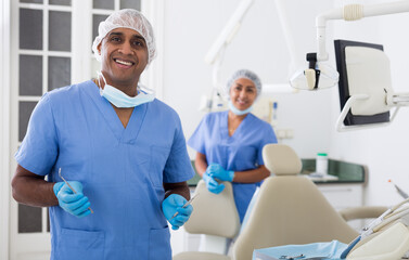 Qualified hispanic stomatologist smiling confidently at camera posing at dental office ..