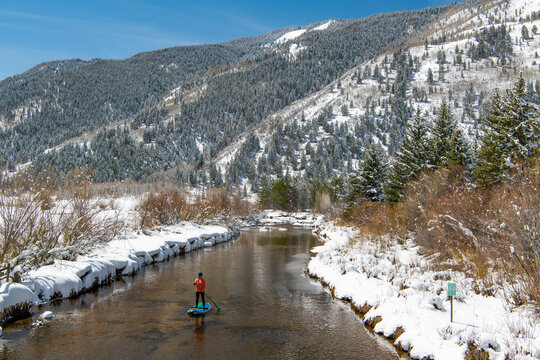 Woman paddleboarding on river during winter