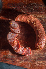 Sliced ​​smoked calabrese sausage in a wooden table,copy space