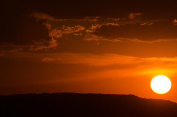 Sun on the horizon over the mountain. Space for text.