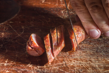 Sliced ​​smoked calabrese sausage in a wooden table,copy space